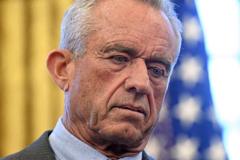 US Secretary of Health and Human Services Robert F. Kennedy Jr. looks down as unseen US President Donald Trump